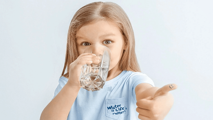 عکس کودک در حال نوشیدن آب برای پیشگیری از یبوست 